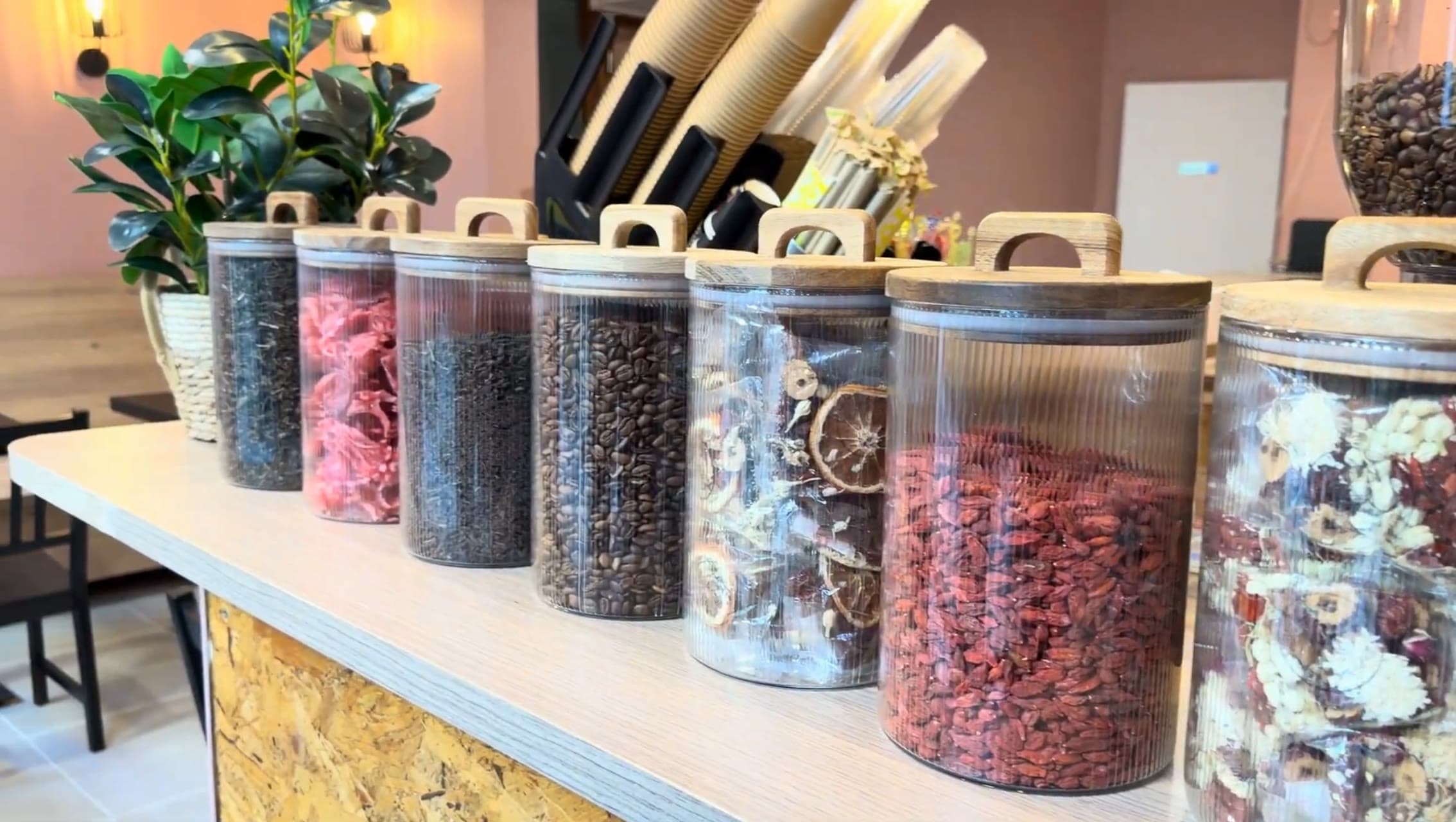 Bocaux de thés, cafés en grains et fruits séchés sur le comptoir
