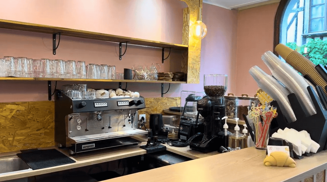 Le comptoir du café : machine à espresso, moulin et étagères de verres